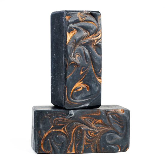 two black soap bars with golden swirls