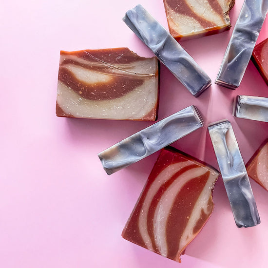 brown and grey soap bars in semi circle on pink background
