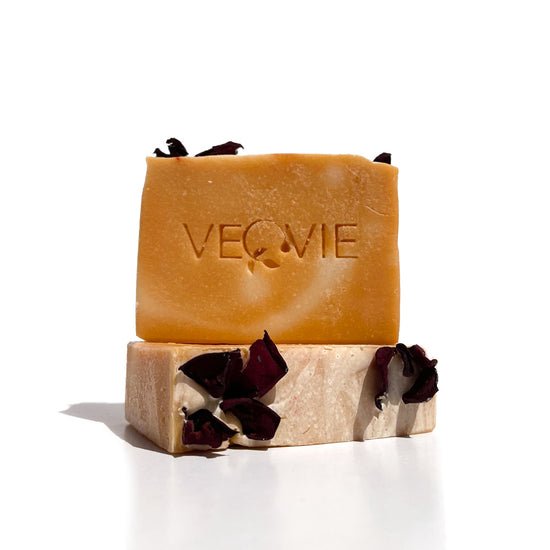 two bars of soap with veovie logo in the center of the soap orange color with rose pettals